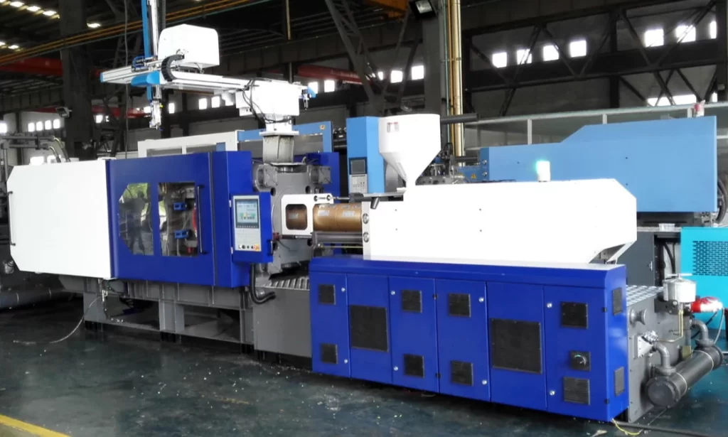 Large blue and white injection molding press on the production floor